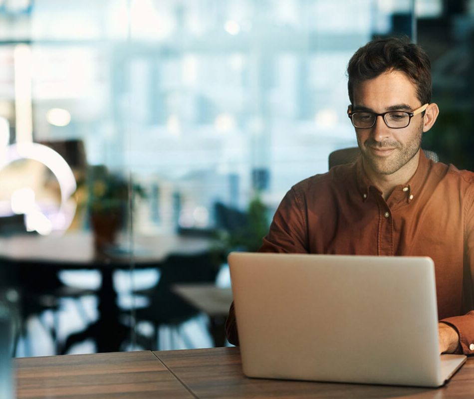 Businessman using a laptop while working late in his office