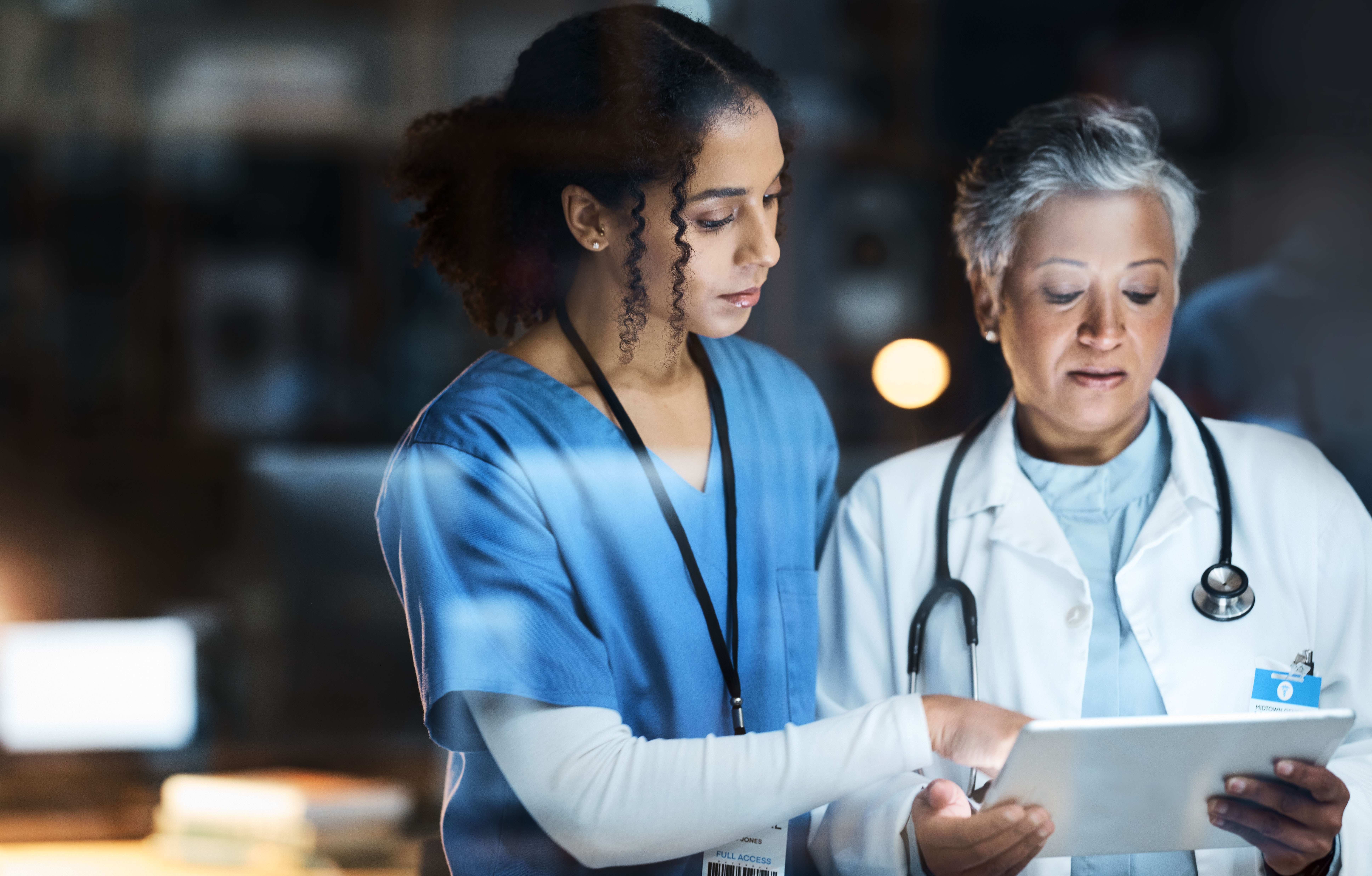 Women, doctors and tablet for night medical research, surgery planning and teamwork in hospital. Nurse, healthcare and worker collaboration on technology in late shift for wellness thinking and ideas