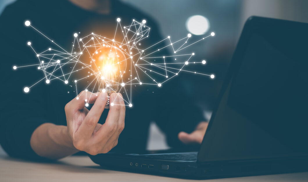 Businessman holding a bright light bulb, creativity with light bulbs and energy power, hand of a man with a light bulb and line light icon and using a notebook computer, technology innovation idea